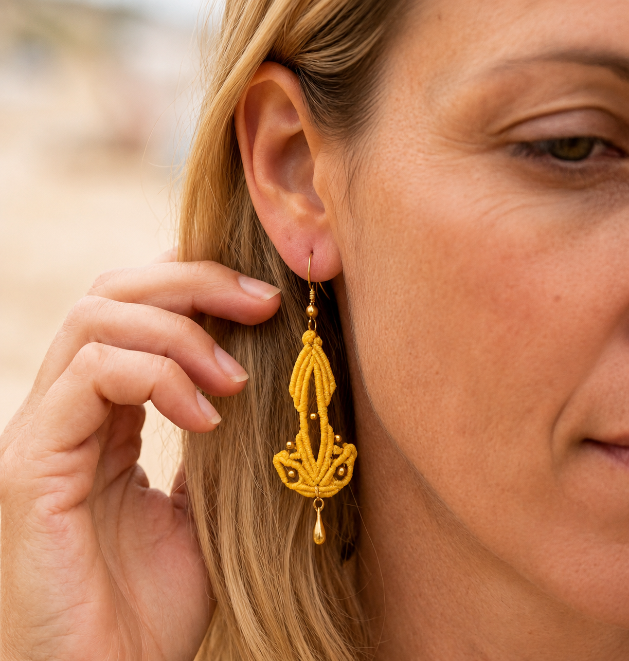 Boucles d'oreilles Safran en micro-macramé jaune moutarde portées à l'oreille – Micro Noeuds