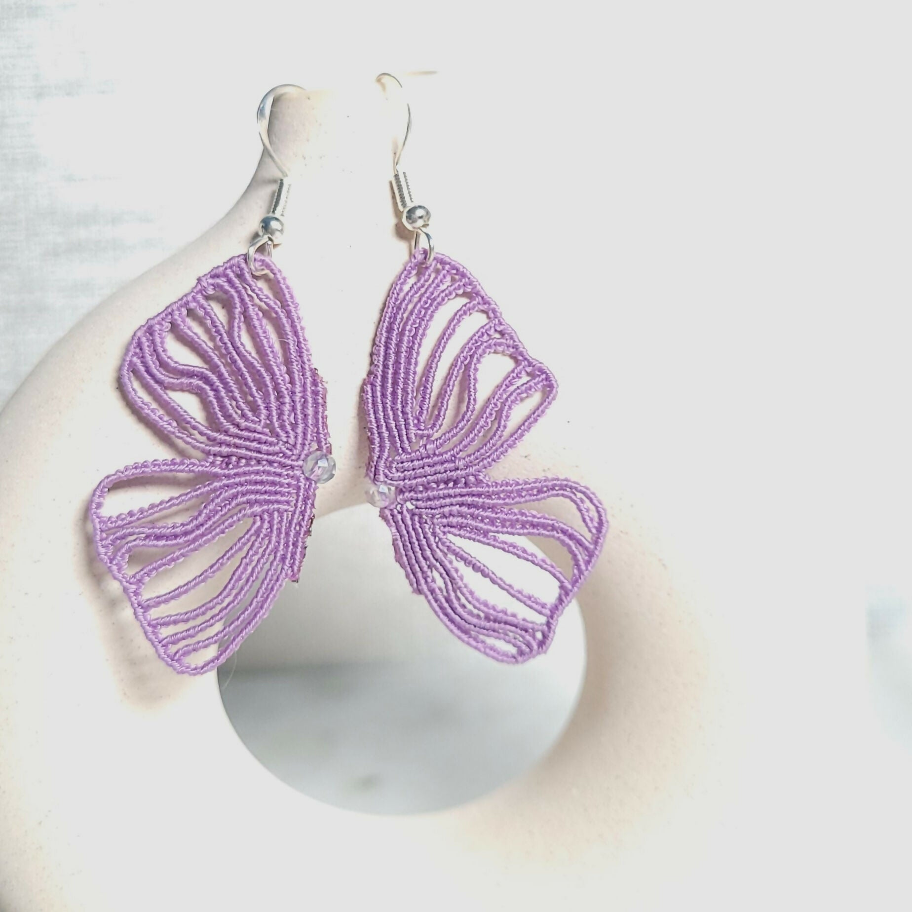 Boucles d'oreilles Elyra, aile de papillon en micro-macramé mauve avec cristal, crochets acier inoxydable, fait main en Belgique