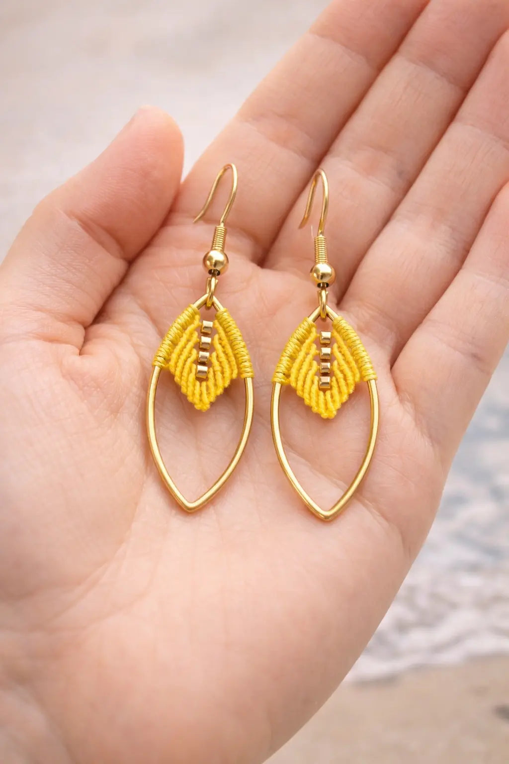 Boucles d’oreilles micro-macramé feuille navette Oraya dans la main